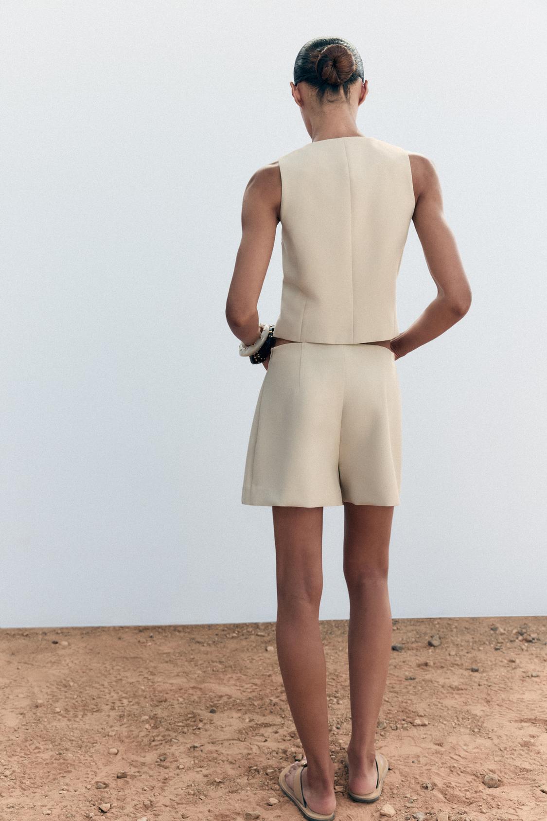 ÄRMELLOSES KNOPFWESTE MIT RUNDAUSSCHNITT